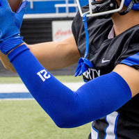 A football player catching a pass. Close-up of his royal arm sleeve with number 21 on the wrist.